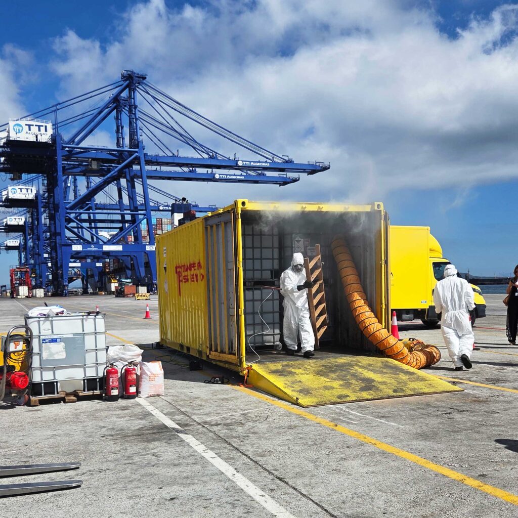 Operarios de TransPiedra con trajes de protección química junto a un contenedor en la Terminal TTI de Algeciras