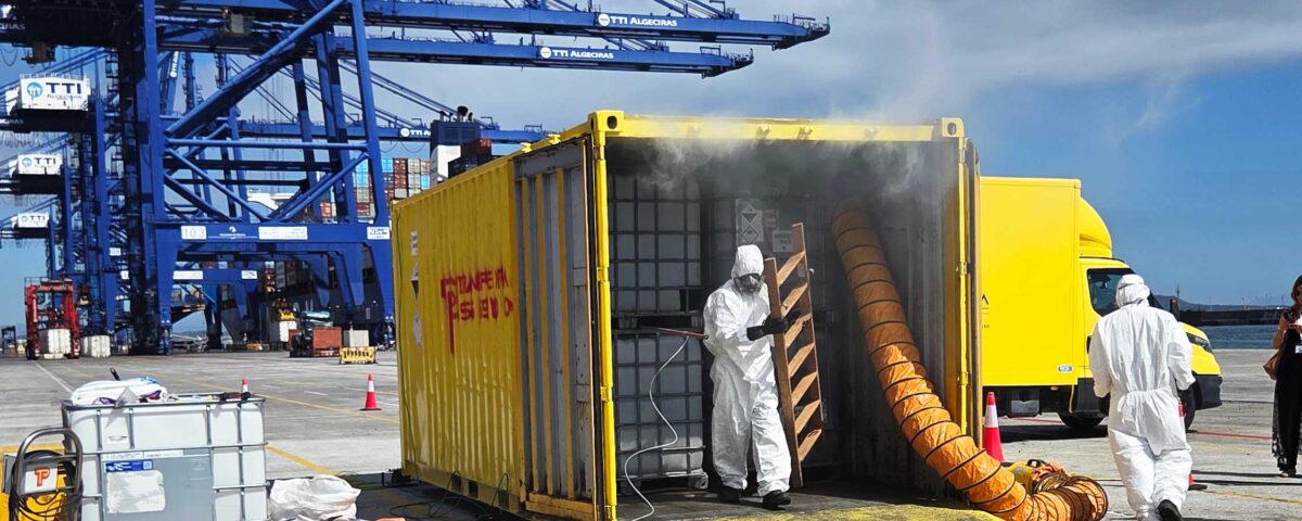 Operarios de TransPiedra con trajes de protección química junto a un contenedor en la Terminal TTI de Algeciras